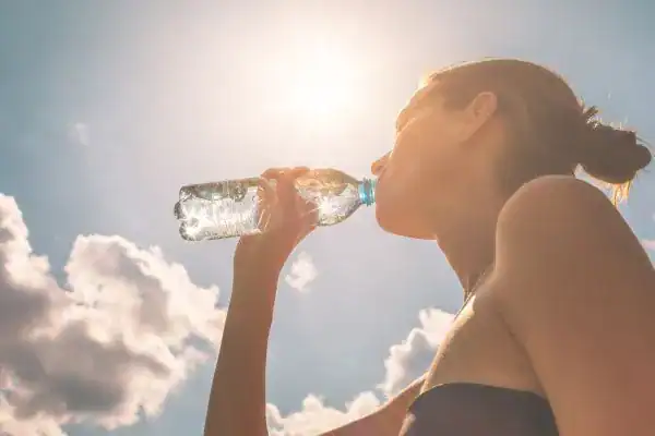 Hydration: The Secret Ingredient for a Toned Stomach and Enhanced Fitness 3 Image of woman drinking water to hydrate Warwickshire after run.