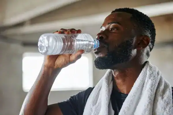 Hydration: The Secret Ingredient for a Toned Stomach and Enhanced Fitness 1 Image of man drinking water to improve hydration Warwickshire after work out.
